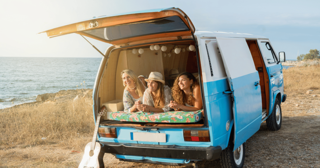 BEST CAMPING OPTION THIS IS AN IMAGE OF GIRLS CAMPING IN BACK OF CAMPER VAN