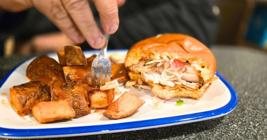 Blue Hen Cafe: St. Augustine’s Best Breakfast Spot THIS IS AN IMAGE OF A MAN EATING THE BAJA FISH SANDWICH