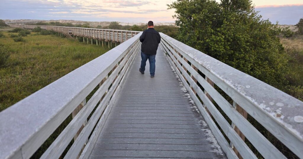 Ultimate Guide to Florida State Parks man on boardwalk at sunset