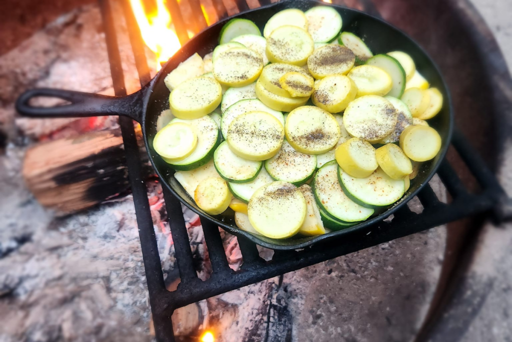 CAST IRON SKILLET WITH SQUASH ON CAMPFIRE CAMPFIRE COOKING