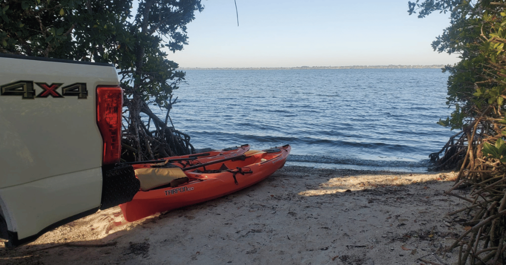 BRGINNER'S GUIDE TO CAMPING THIS IS AN IMAGE OF 2 KAYAKS AT WATER