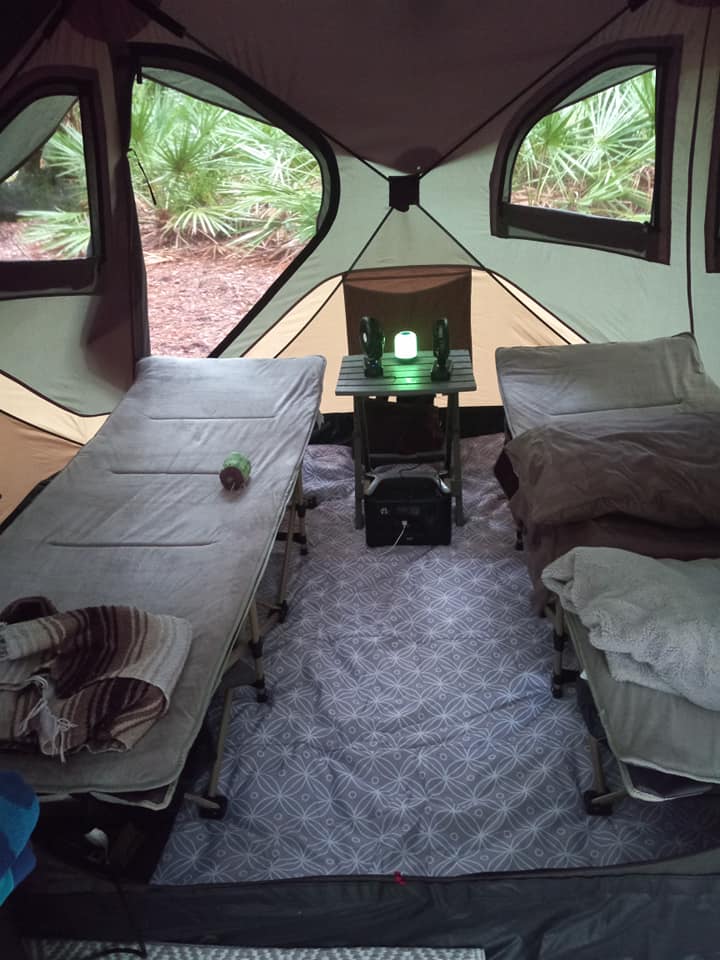 Stay cool while you sleep with Expedition Cool: Best Battery Operated Fans For Camping! cots in tent with table in center