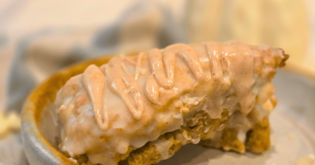 PUMPKIN WHITE CHOCOLATE SCONES WITH BOURBON MAPLE GLAZE SCONE ON A PLATE