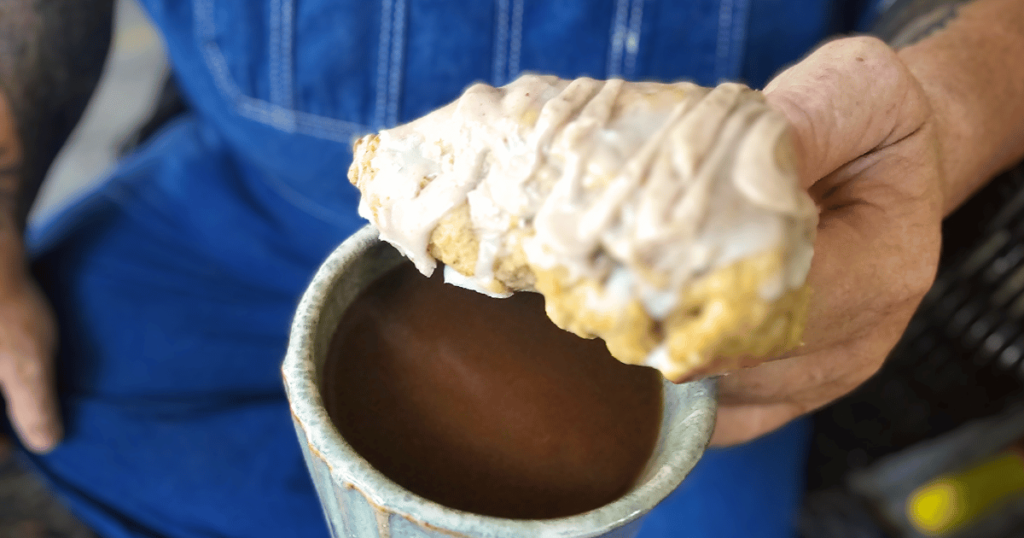 PUMPKIN WHITE CHOCOLATE SCONES WITH BOURBON MAPLE GLAZE MAN WITH COFFEE CUP AND SCONE