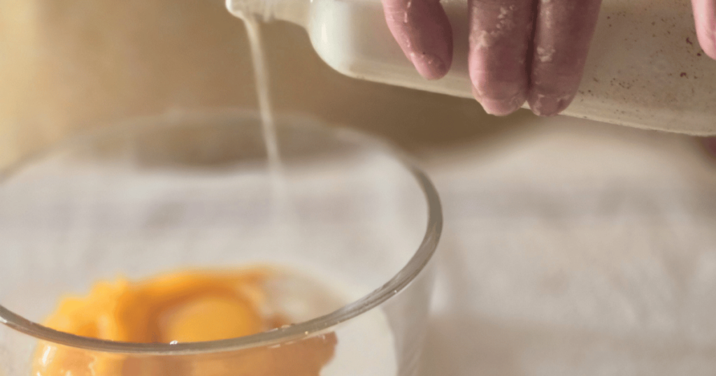 PUMPKIN WHITE CHOCOLATE SCONES WITH BOURBON MAPLE GLAZE POURING HEAVY CREAM INTO BOWL