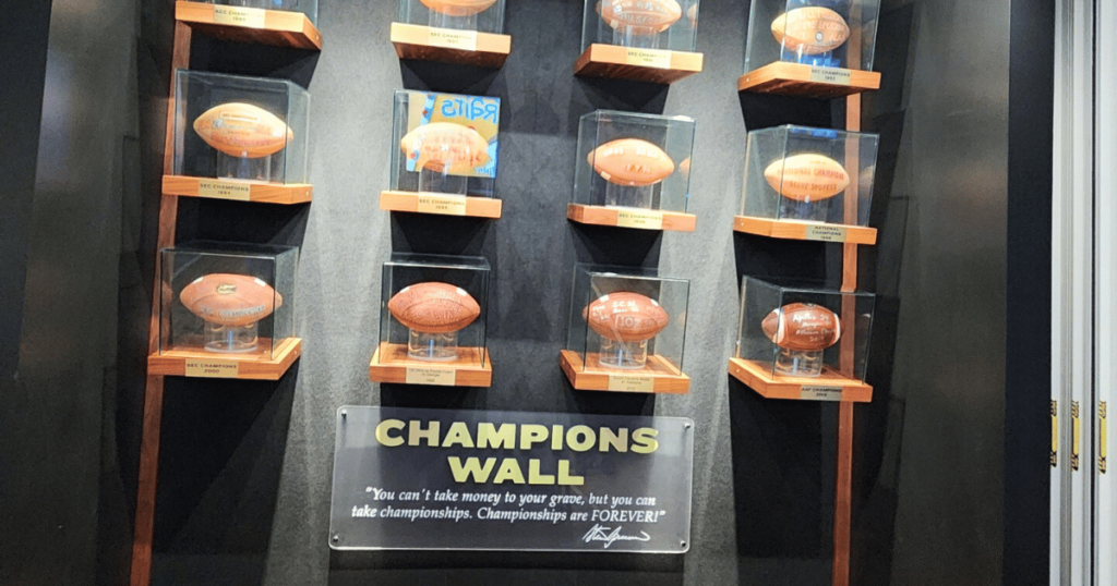 HUDDLE UP THIS FALL TO SPURRIER’S GRIDIRON GRILLE FOOTBALLS ON WALL