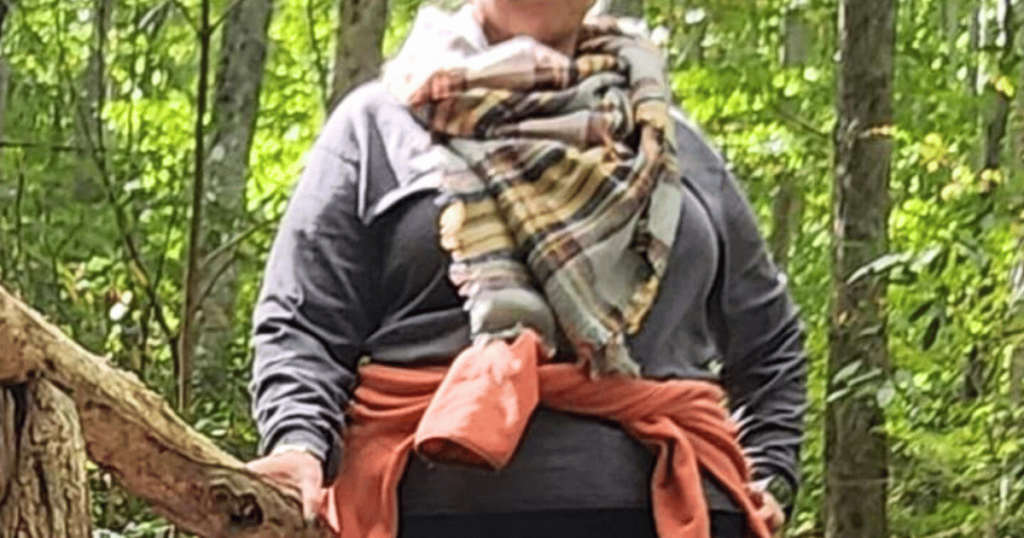 ULTIMATE CLOTHES GUIDE FOR YOUR FALL CAMPING TRIP WOMEN IN LAYERS IN WOODS