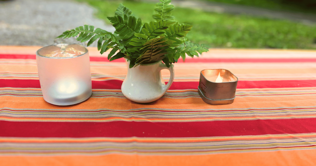 LET'S GET LIT EASY OUTDOOR CAMPSITE LIGHTING IDEAS inflatable lite on picnic table with fern and a candle