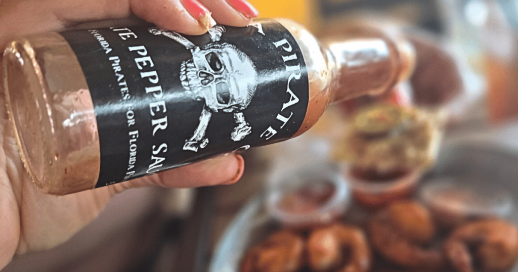 DIVE INTO CRUMPS' LANDING IN HOMOSASSA, FLORIDA this is an image of putting hot sauce on smoked fish dip