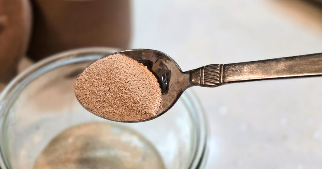 this is an image of adding yeast to a bowl of water