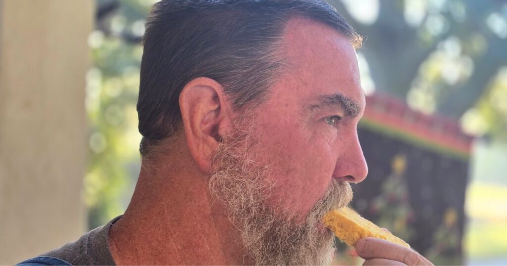 man eating honey cornmeal yeast bread