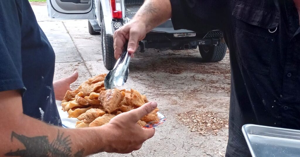 SOUTHERN FISH FRY PARTY IDEAS MAN PUTTING FRIED FISH ON A PLATE