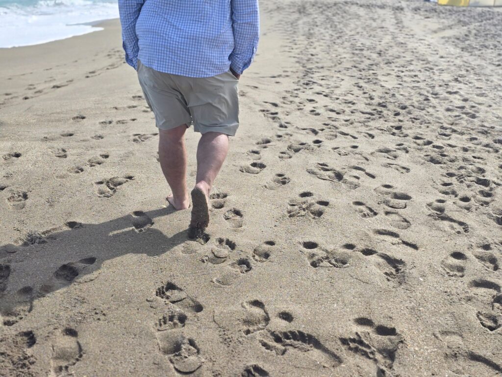 BEACH BAG ESSENTIALS MAN WALKING ON BEACH