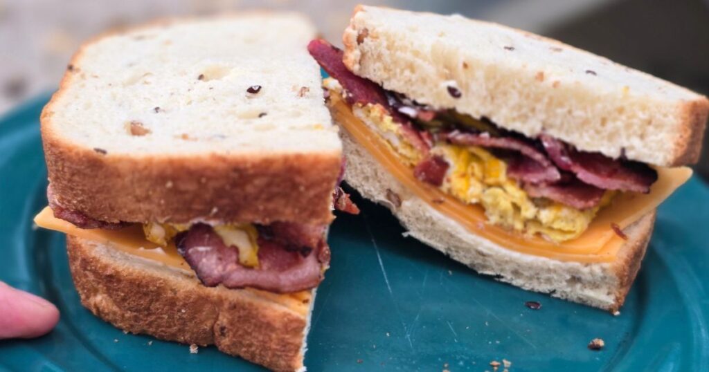THIS IS AN IMAGE OF A CUT BREAKFAST SANDWICH ON A BLUE PLATE