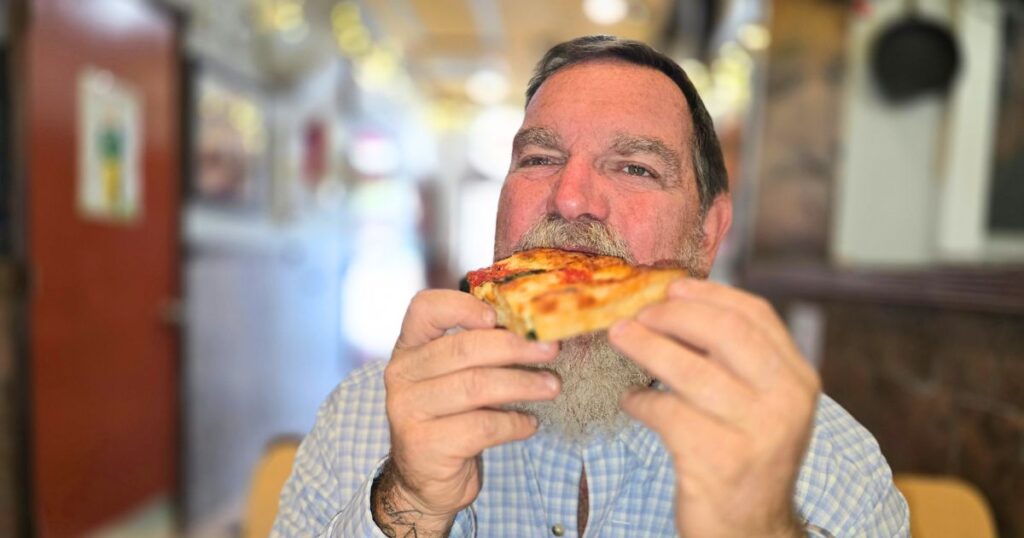 ST. AUGUSTINE FOOD CRAWL THIS IS AN IMAGE OF A MAN EATING PIZZA