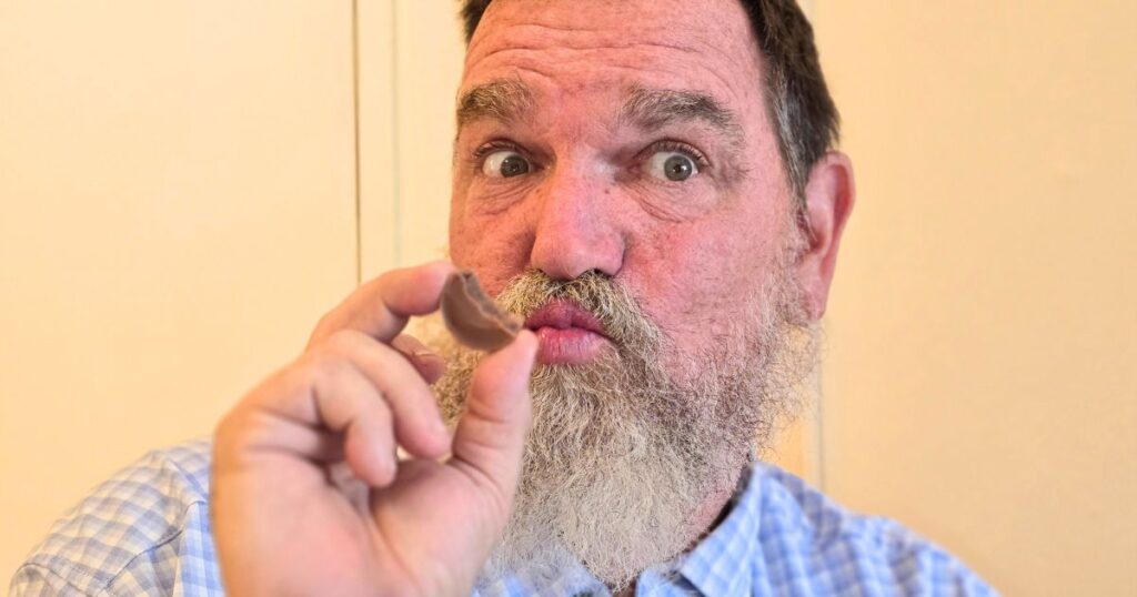 ST. AUGUSTINE FOOD CRAWL THIS IS AN IMAGE OF A MAN EATING A TRUFFLE AT CLAUDS CHOCOLATES