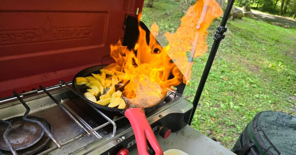 THE BEST PORTABLE CAMPING STOVES THIS IS AN IMAGE OF THE CAMP CHEF EVEREST 2X WITH FLAMES COMING OUT OG PAN