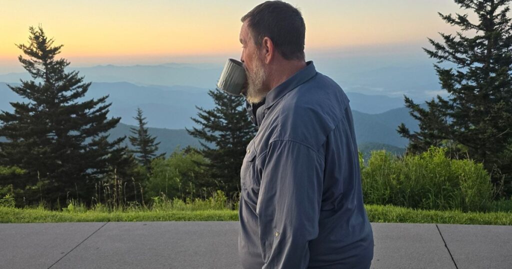 THIS IS AN IMAGE OF A MAN DRINKING COFFE MADE FROM THE JETBOIL STASH