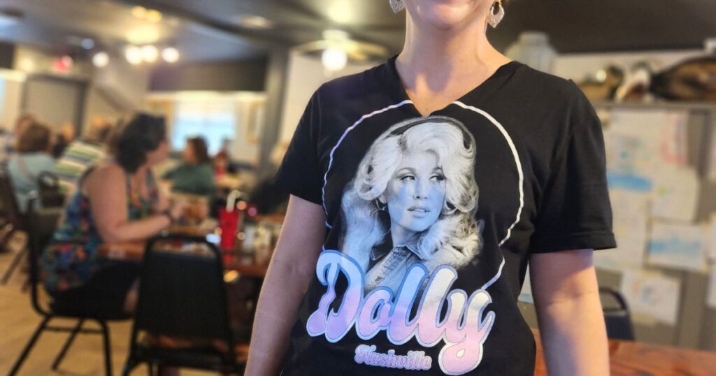 GATOR SHACK RESTAURANT THIS IS AN IMAGE OF A WAITRESS WEARING A DOLLY PARTON T-SHIRT