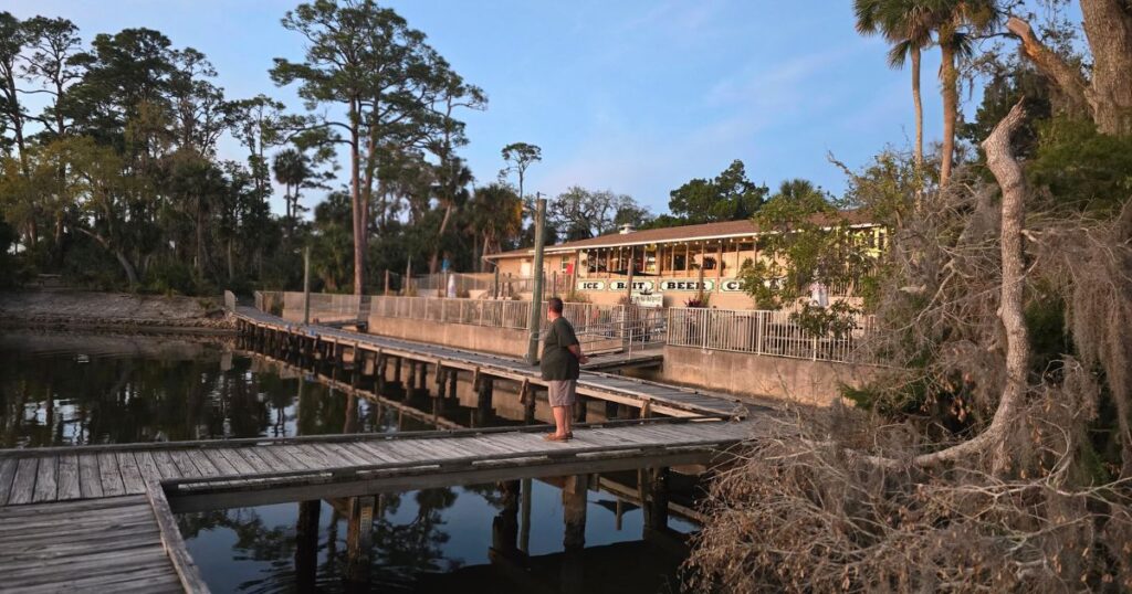 THIS IS AN IMAGE OF A MAN ON A DOCK BEHIND TOMOKA OUTPOST