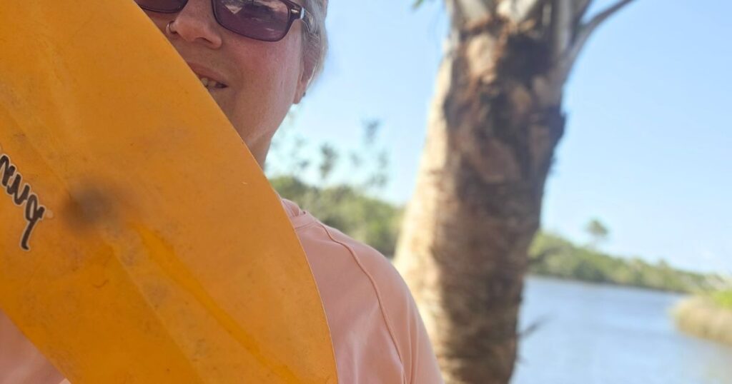 THIS IS AN IMAGE OF A WOMAN HOLDING A KAYAK PADDLE