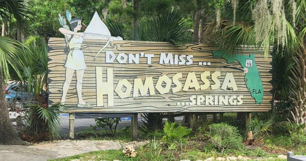 Homosassa Springs sign with Native American and alligator illustration, Florida travel destination.