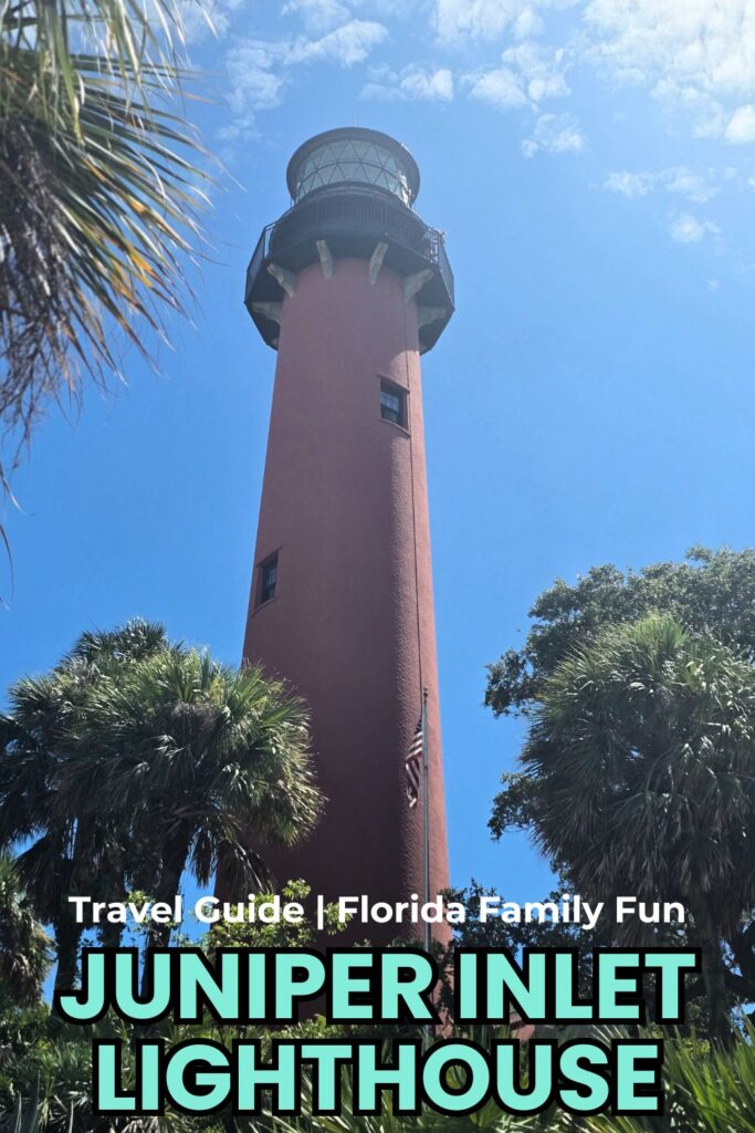 Julian Inlet Lighthouse in Florida, tall pink structure amidst tropical foliage under bright blue sky.