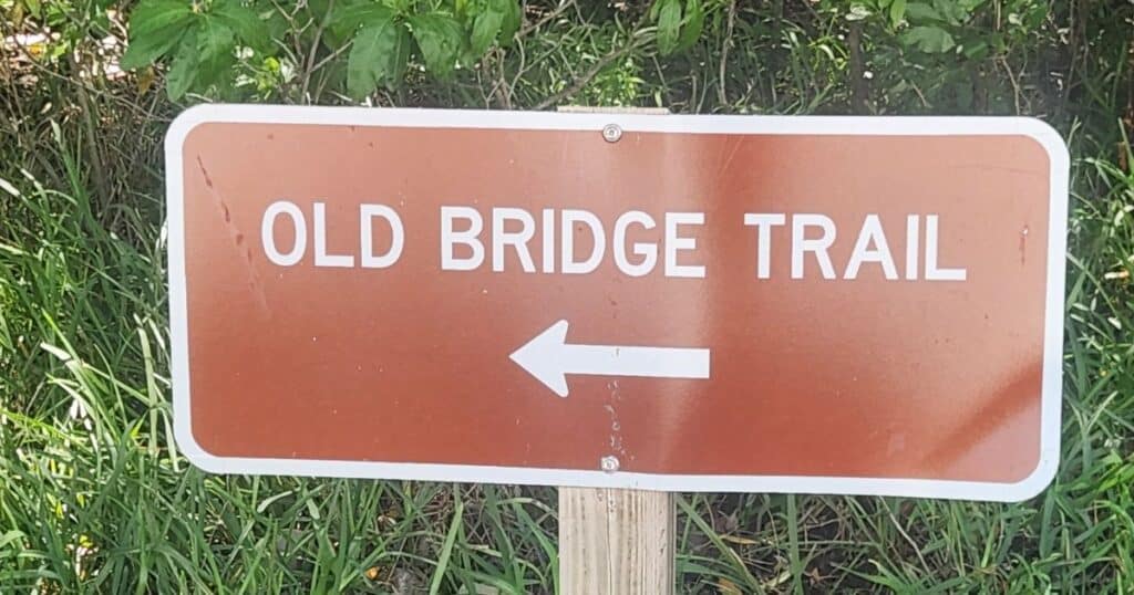Old Bridge Trail directional sign at a nature trail.