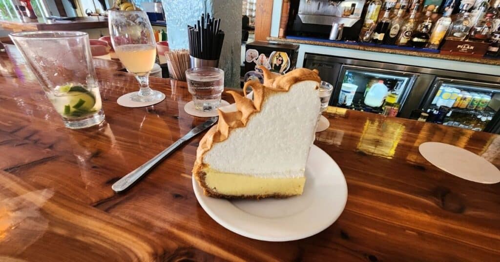 Creamy cheesecake with meringue topping at a lively bar or restaurant.