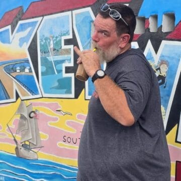 Kayaking mural artwork on vibrant colorful wall at The Wandering Hulasquatch, outdoor scene.