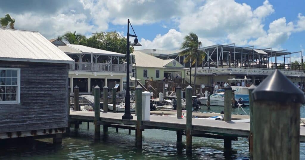Dockside marina with boats and waterfront restaurants in tropical paradise.