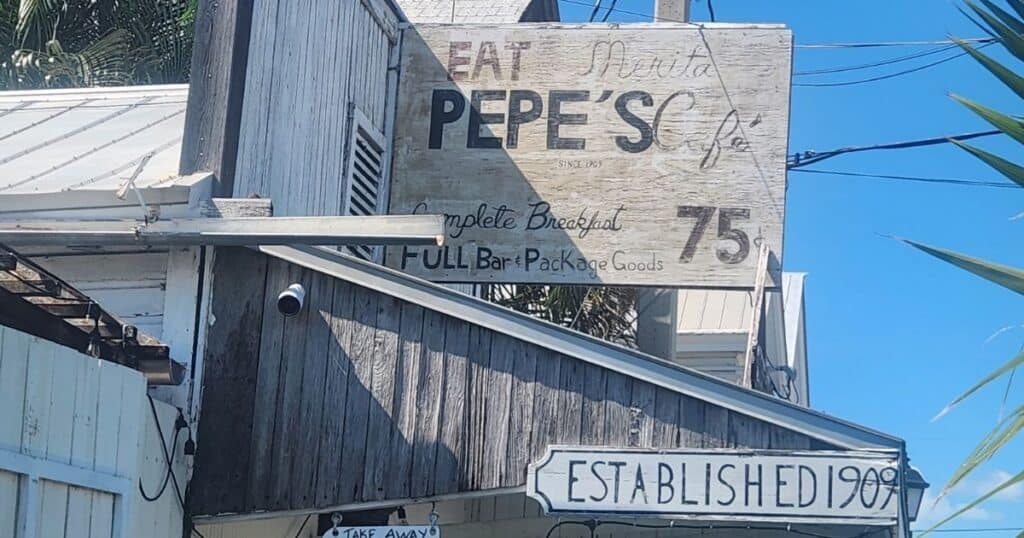 Rustic roadside sign for Pepe's restaurant offering breakfast and bar packages, established since 1903.