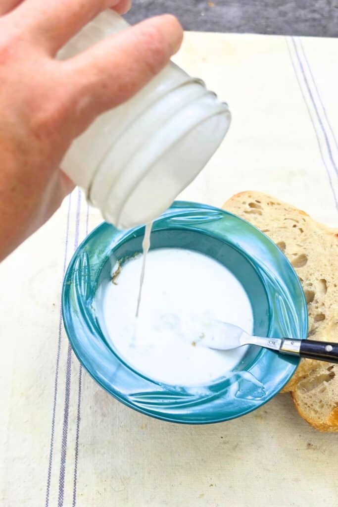 EASY CAMPING BREAKFAST RECIPE IMAGE POURING COCONUT MILK INTO BOWL
