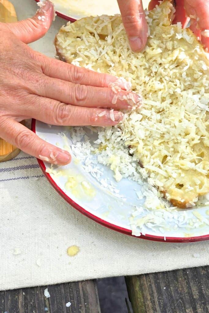 FRENCH TOAST RECIPE IMAGE OF DIPPING & ROLLING BREAD IN SHREDDED COCONUT ON A PLATE