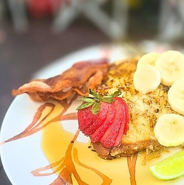 PINA COLADA FRENCH TOAST EASY CAMPING BREAKFAST RECIPE FRENCH TOAST ON A PLATE WITH FRESH FRUIT