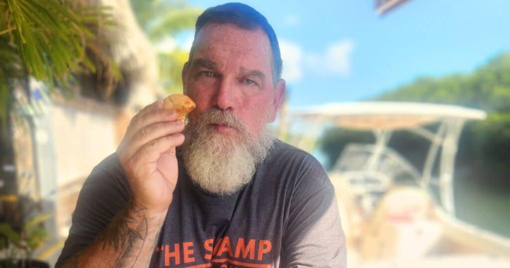 Guest enjoying peel-and-eat shrimp at Geiger Key Marina seafood restaurant, Florida Keys