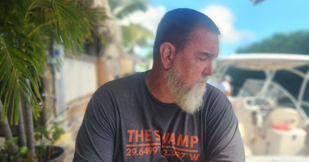 Diner looking at canal from dockside seating at Geiger Key Marina, Old Florida Keys restaurant